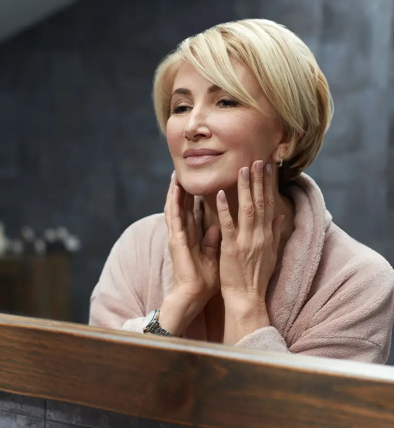 Older woman touching face | Facelift